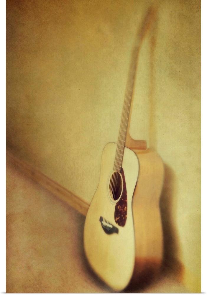 Guitar leaning a against a wall.
