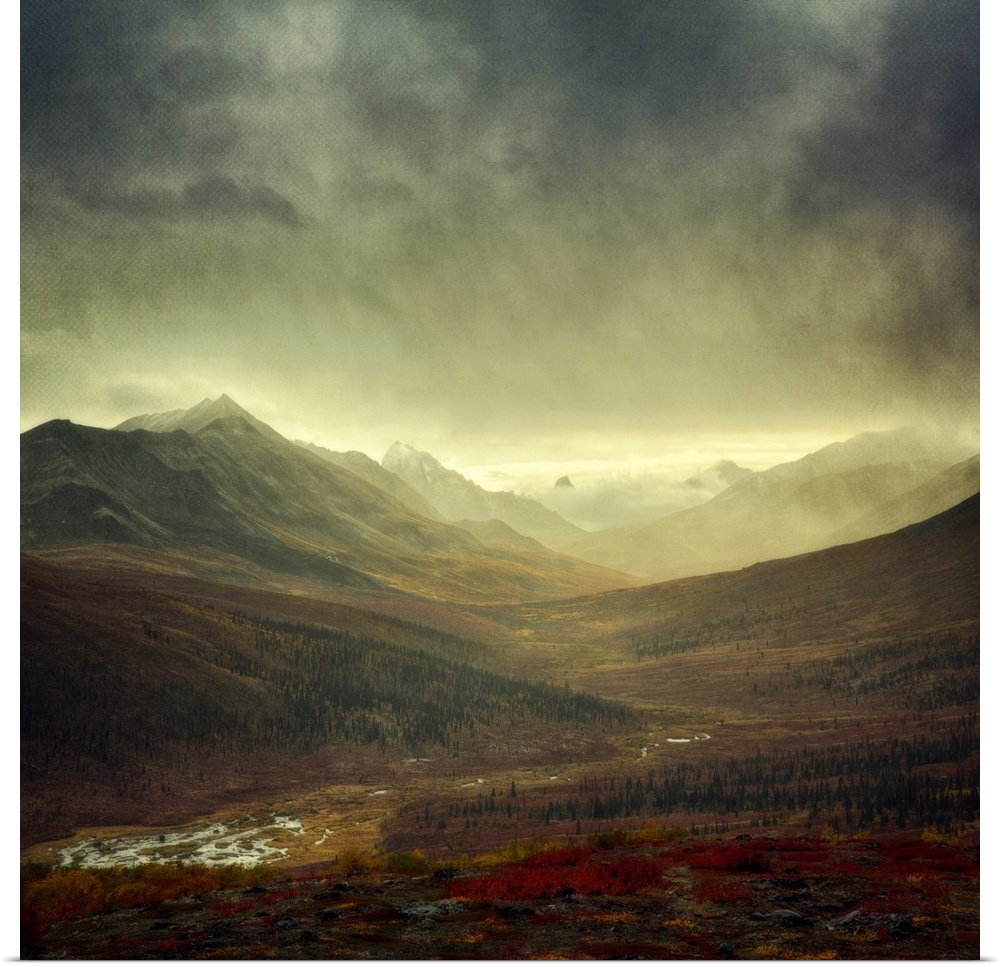 An artistic photograph of a mountain valley under a dark sky.
