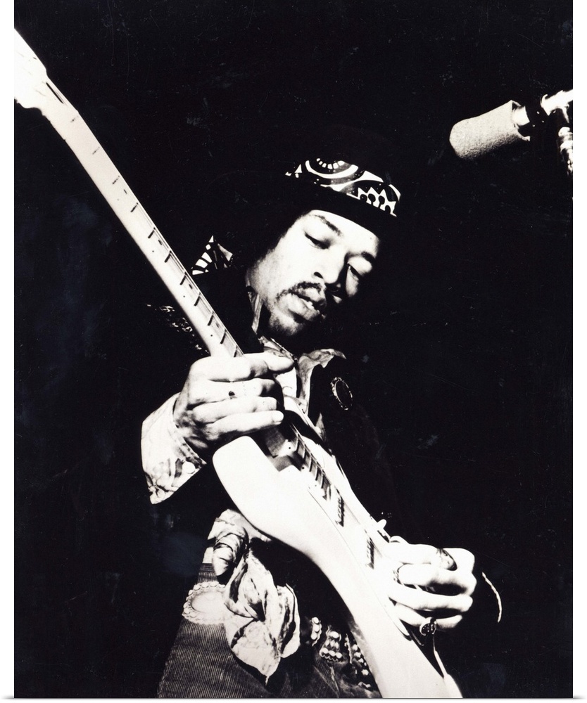 Old black and white photograph of Jimi Hendrix playing the guitar live.