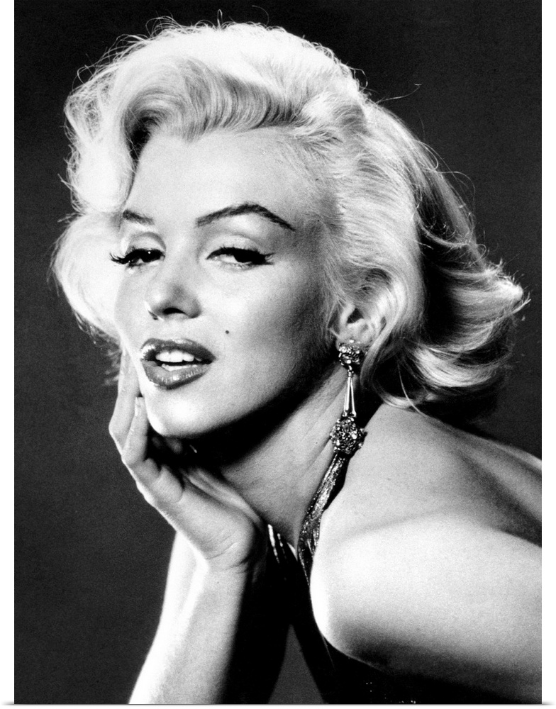 Large, portrait, black and white photograph of Marilyn Monroe, leaning forward with her palm on her face.