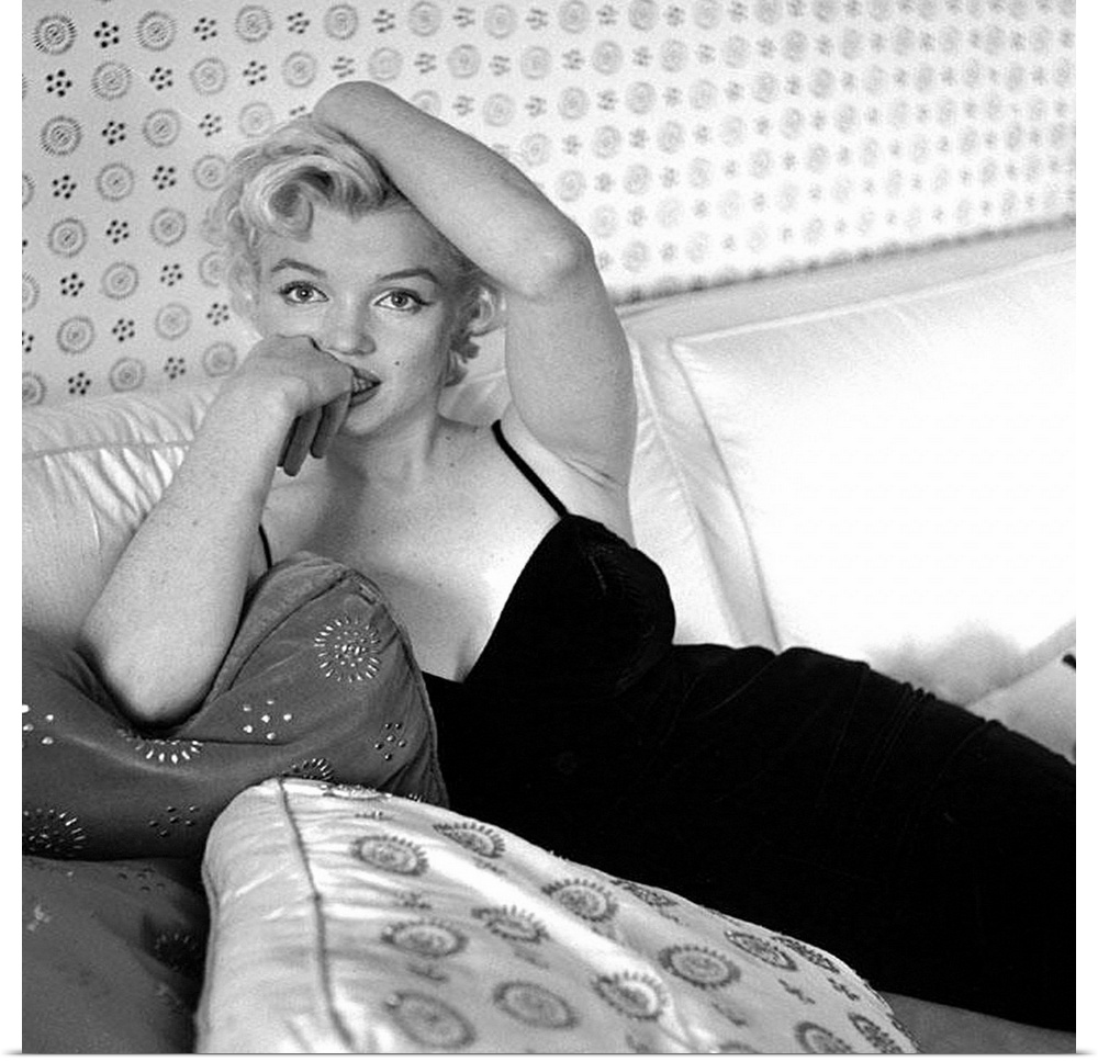 Wall art of Marilyn Monroe sitting on a sofa looking at the camera.