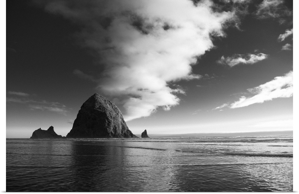 Black and white photograph of Haystack Rock with rippling waters.