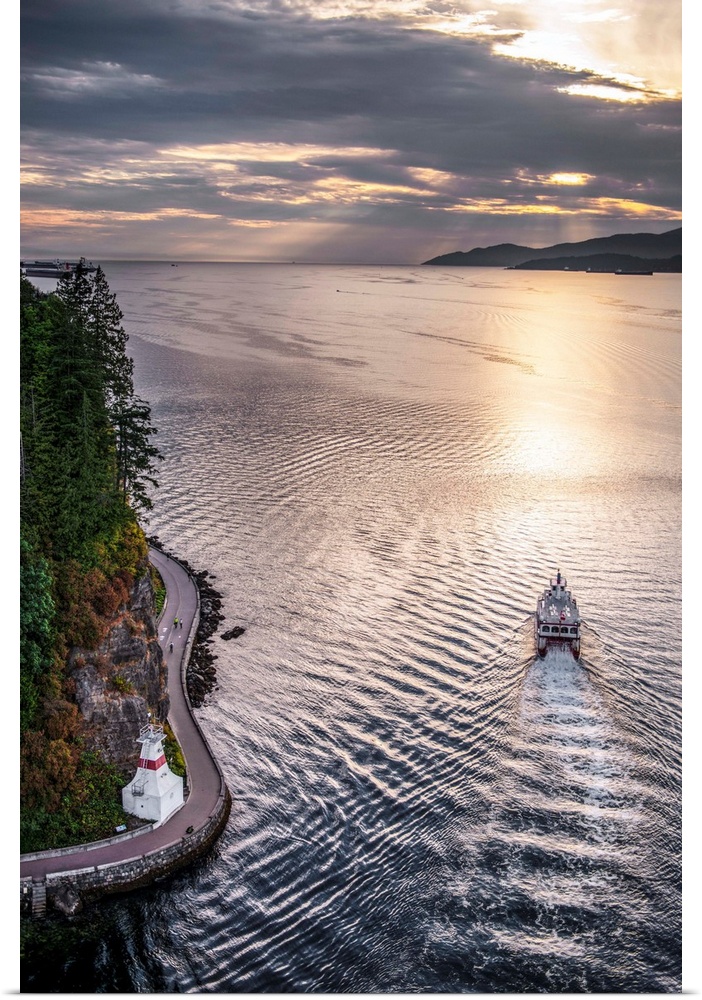 Aerial view of boat in Burrard Inlet with Stanley Park Seawall Path in Vancouver, British Columbia, Canada.