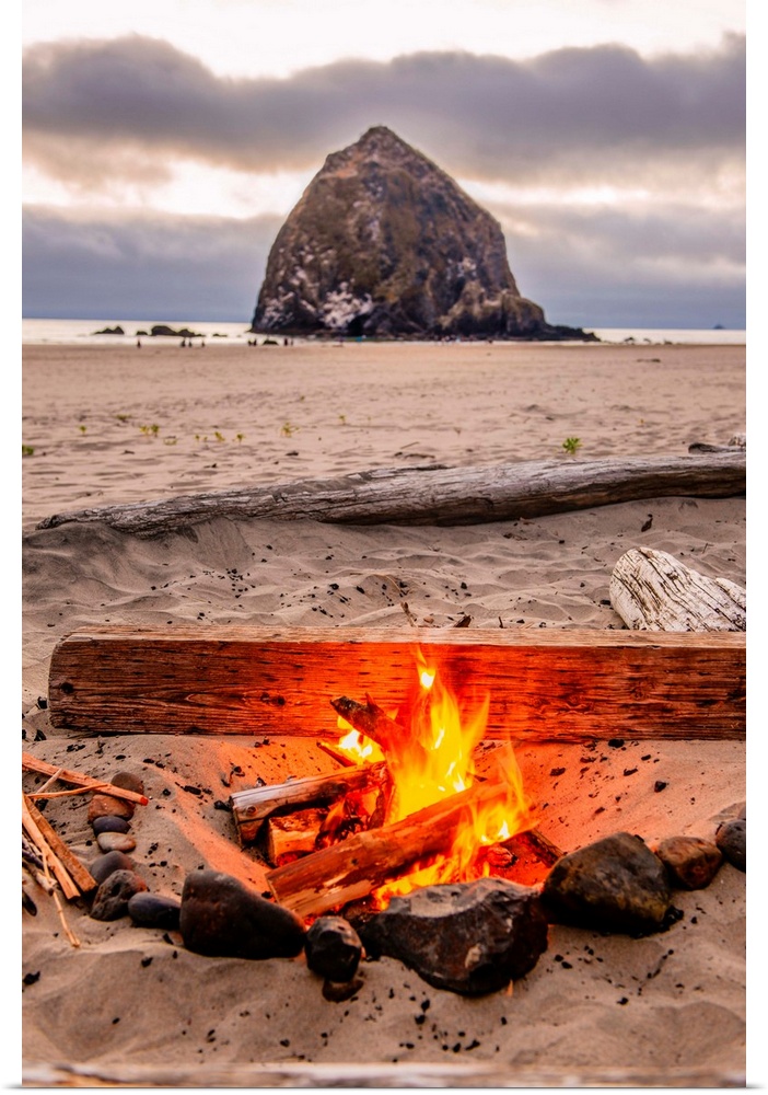 Photograph of a fire on the beach with Haystack Rock in the background at Cannon Beach, Oregon.