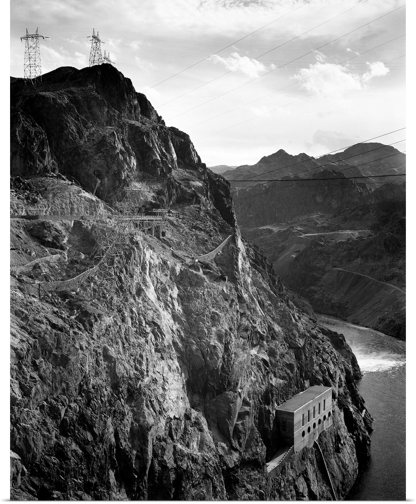Boulder Dam, 1941, vertical of side of cliff with transmission lines above, river to left.