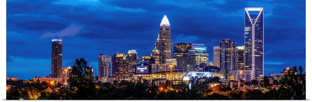 Horizontal image of Charlotte, North Carolina at night with clouds in the sky.