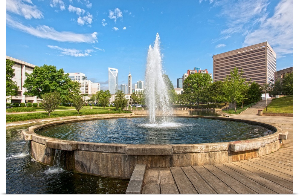 A water fountain in the foreground and Charlotte skyline in the background.
