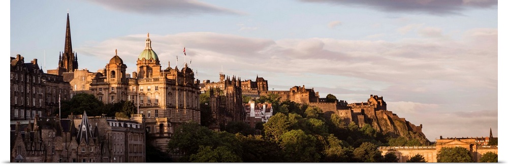 Panoramic photograph of part of the city of Edinburgh with the castle in the background, at golden hour.