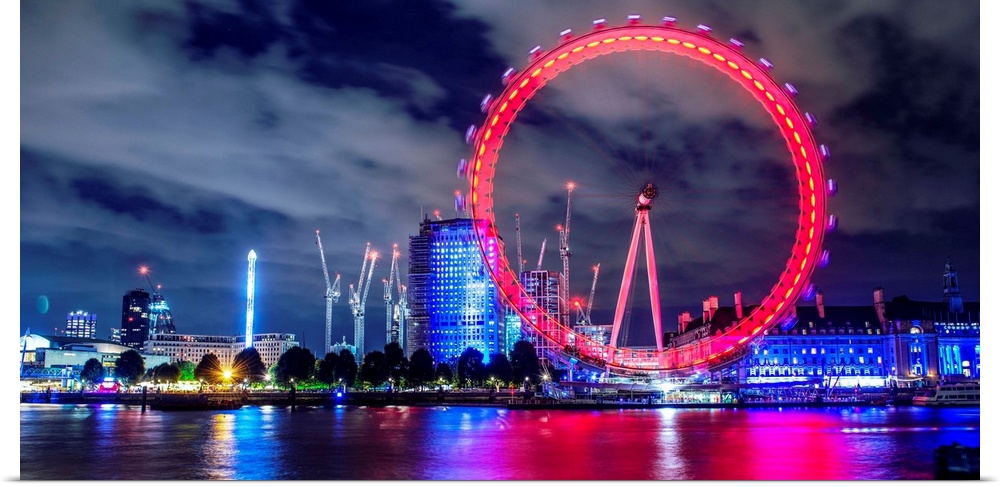 View of the brightly colored ferris wheel at night in London, England.