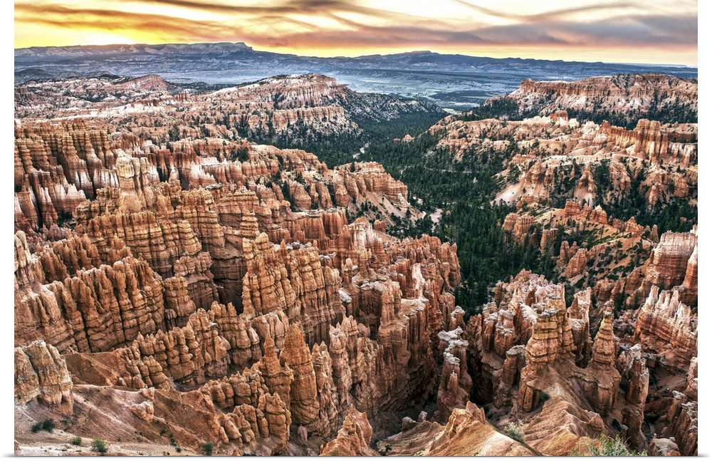 Striped orange and white hoodoos and green pine trees under fiery sunset clouds in Bryce Canyon Amphitheater, Bryce Canyon...