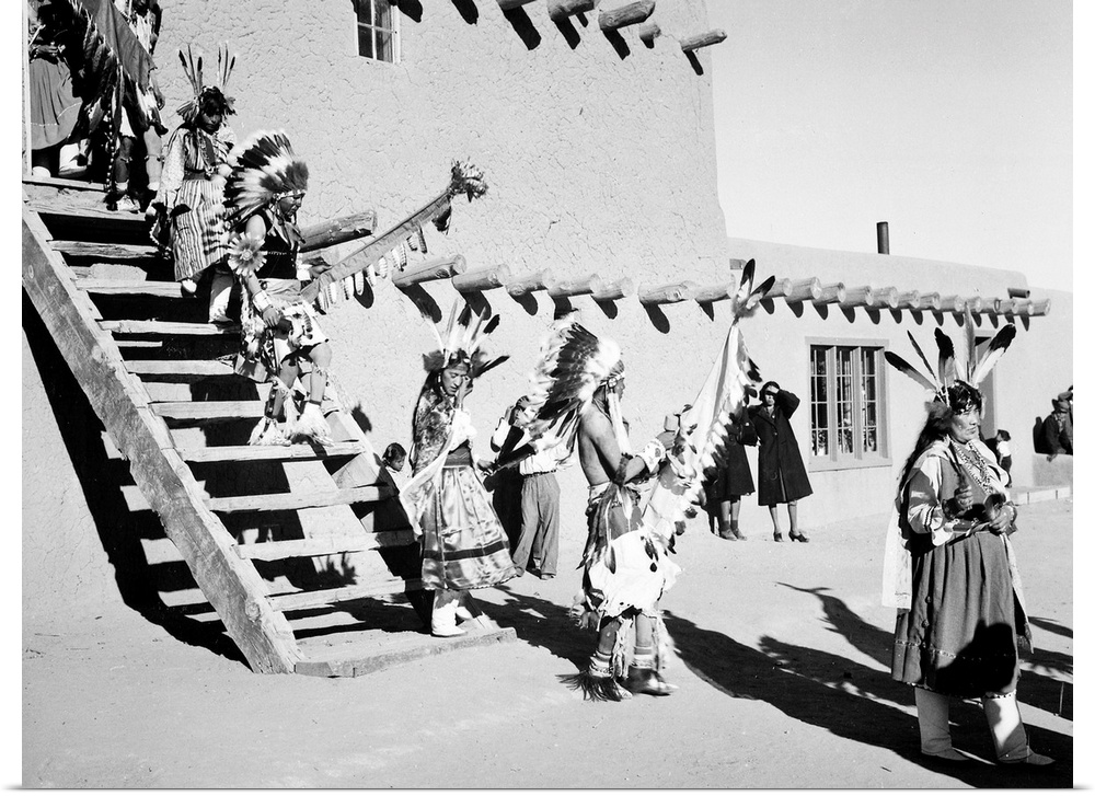 Dance, San Ildefonso Pueblo, New Mexico,Indians in headdress, male and female, descending stairs.
