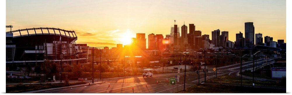 Panoramic photo of a Denver skyline against a breathtaking sunrise.