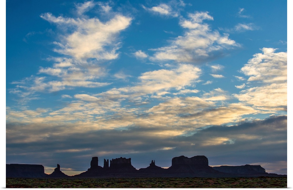 Silhouette of Sentinel Mesa, Big Indian, Stagecoach and Brighams Tomb rock formations, Monument Valley, Utah.
