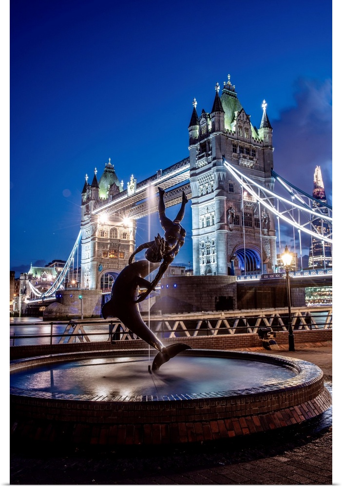View of the Girl with a Dolphin Fountain with Bridge Tower at night in London, England.