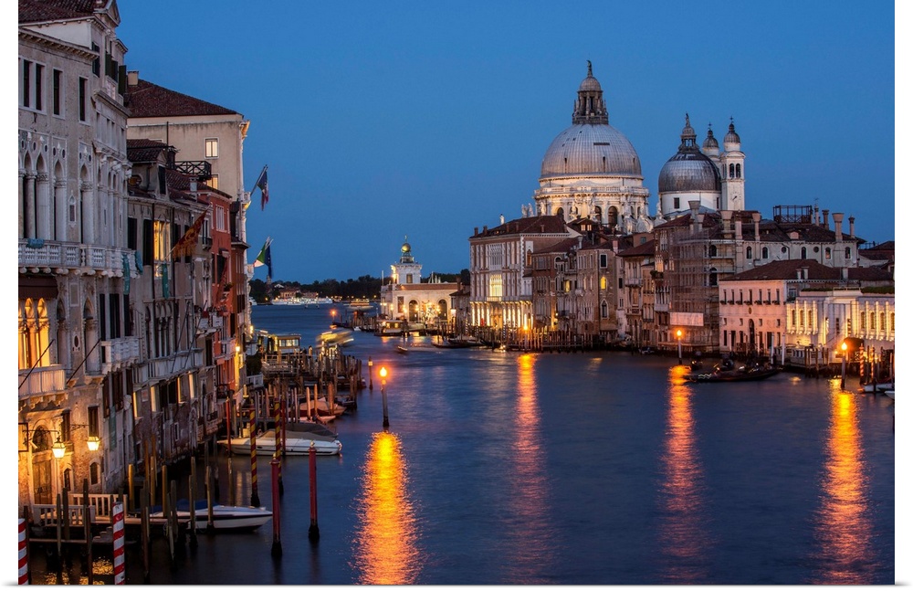 Photograph of Grand Canal lit up at night with the Santa Maria della Salute in the background.