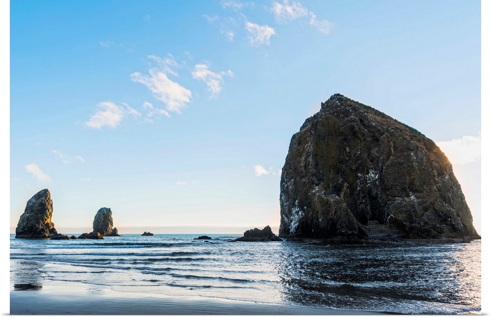 Photograph of Haystack Rock at Cannon Beach with blue skies.