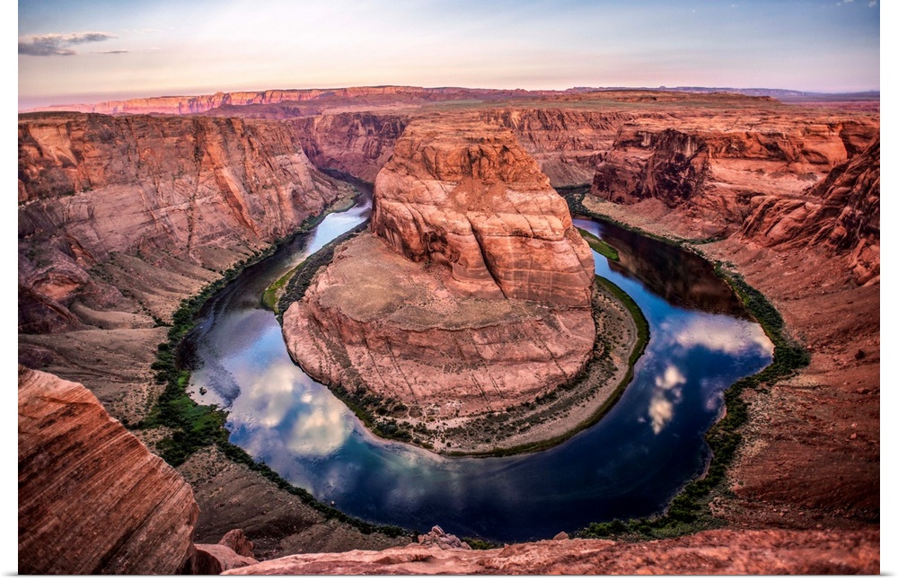 Landscape photograph of Horseshoe Bend in Page, Arizona with blue cloudy skies reflecting into the Colorado River.