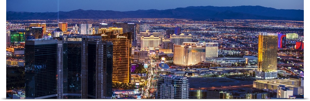 Panoramic photograph of an aerial view of the Las Vegas strip lit up at night.