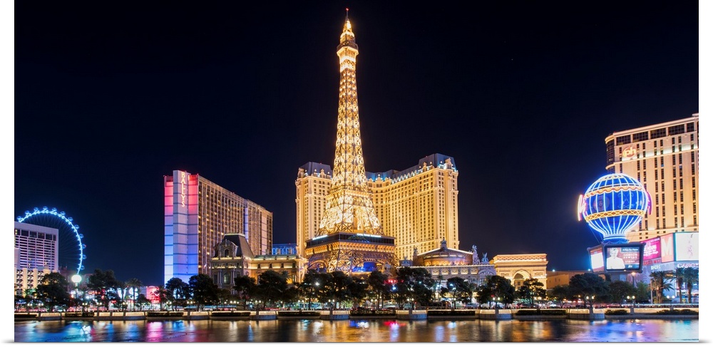 Panoramic photograph of the Las Vegas Strip lit up at night highlighting the Eiffel Tower Restaurant, hot air balloon, and...