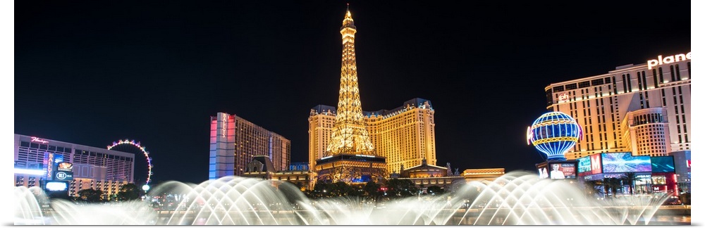 Panoramic photograph of the Las Vegas strip at night with the Bellagio Fountain water show in the foreground.