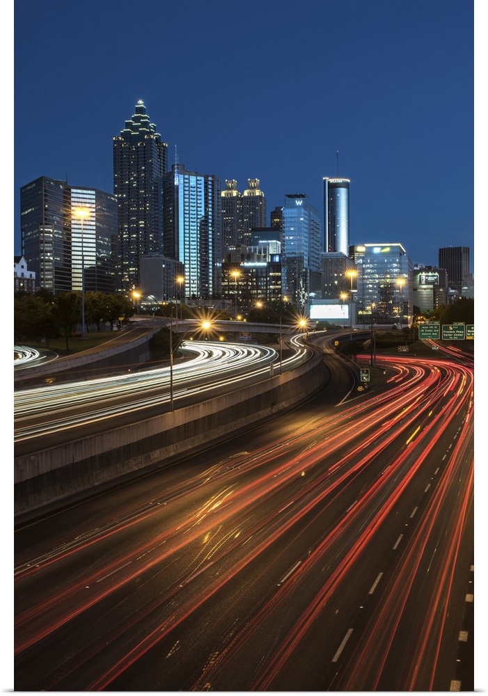 Light trails from passing cars on the road headed towards the Atlanta, Georgia skyline at night.