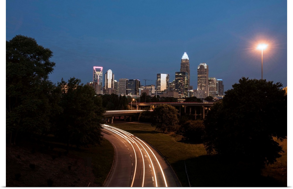 Light trails fill the foreground with Charlotte skyline in the background.