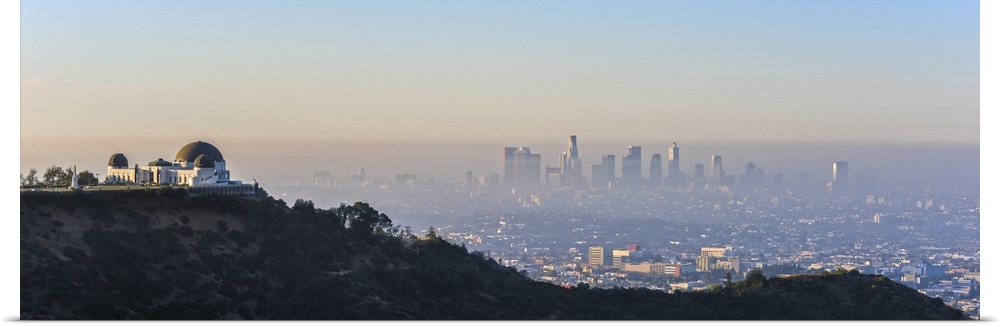 Panoramic photograph of the hazy Los Angeles skyline with Griffith Observatory on the left in the foreground.