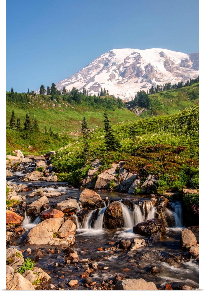 View of a tranquil waterfall with Mount Rainier peak in the background, Mount Rainier National Park, Washington.