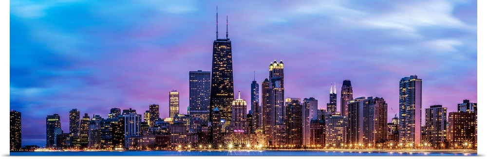 Photo of Chicago skyline at night under cotton candy colored clouds.