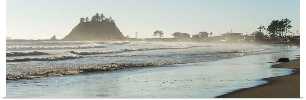 Panoramic landscape photograph of the La Push Beach shore with misty rock cliffs in the background.