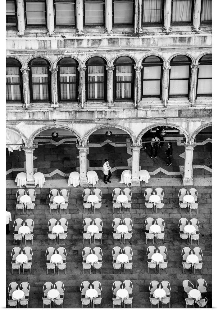 Photograph of tables and chairs in rows outside of a building in St. Mark's Square in Venice, Italy.