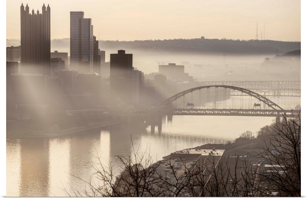 View of downtown Pittsburgh with Fort Pitt Bridge over the Monongahela River on a foggy day.