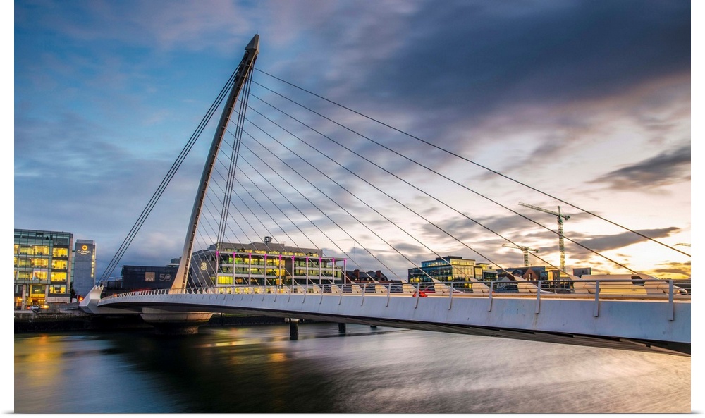 Photograph of the Samuel Beckett Bridge, a cable-stayed bridge in Dublin, Ireland going across the River Liffey, at sunset.