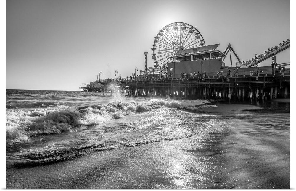 Photograph of the Santa Monica Pier in Los Angeles, California, with the sun setting right behind the Ferris Wheel.