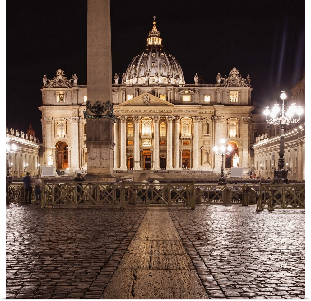 Square photograph of St. Peter's Basilica  lit up at night.