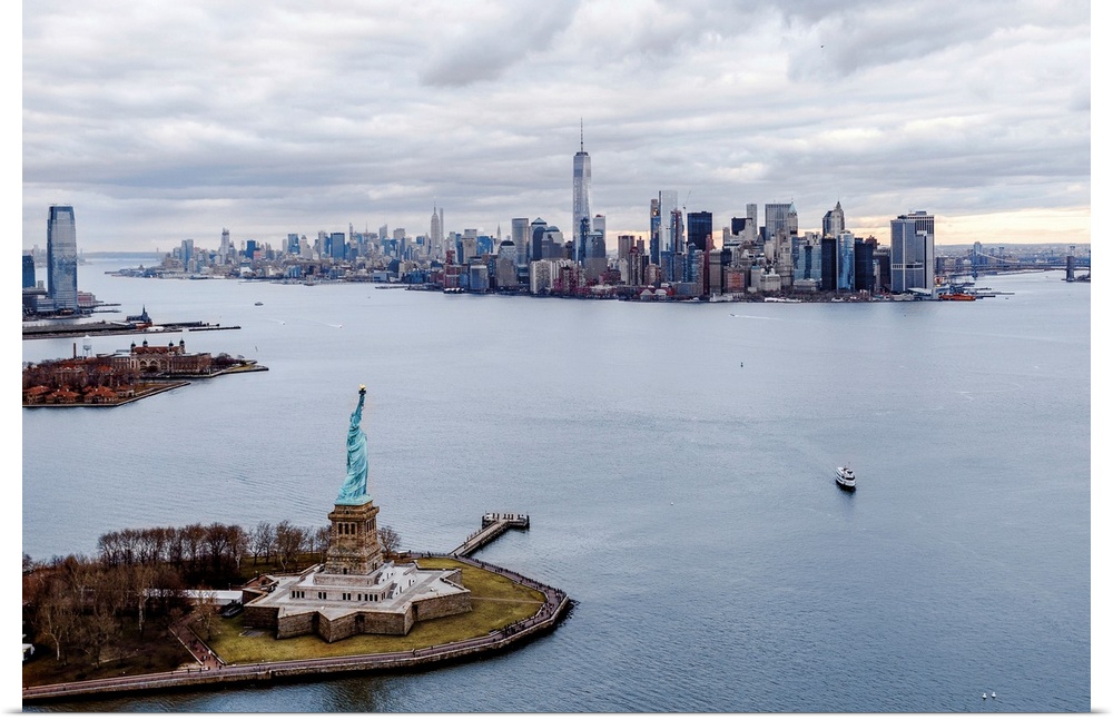 Aerial view of the Statue of Liberty on Liberty Island with the New York City skyline in the distance.