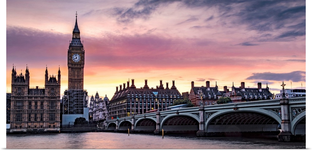 Panoramic photograph of Big Ben and the Westminster Bridge with a pink and purple sunset.