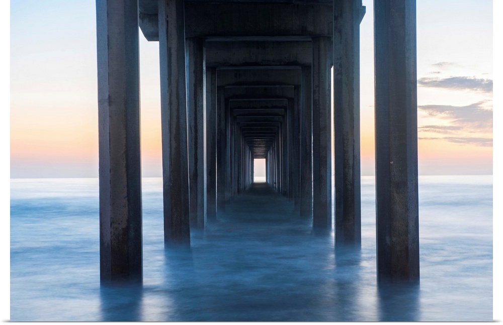 Photograph underneath the Scripps Pier at sunset.