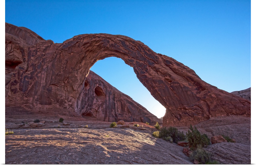 The sun setting behind the Corona Arch in Bootlegger Canyon, Moab, Arches National Park, Utah.
