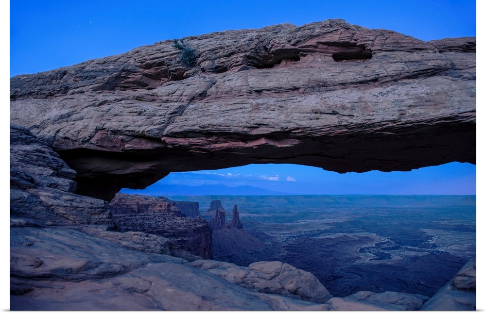 View of rock formations in Buck Canyon, framed by the Mesa Arch in Canyonlands National Park, Moab, Utah.