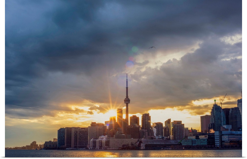 Toronto city skyline under a dramatic sunset with clouds overhead, Ontario, Canada.