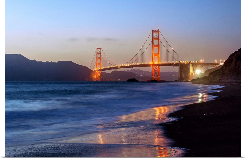 Twilight photograph of the Golden Gate Bridge taken from the shore.