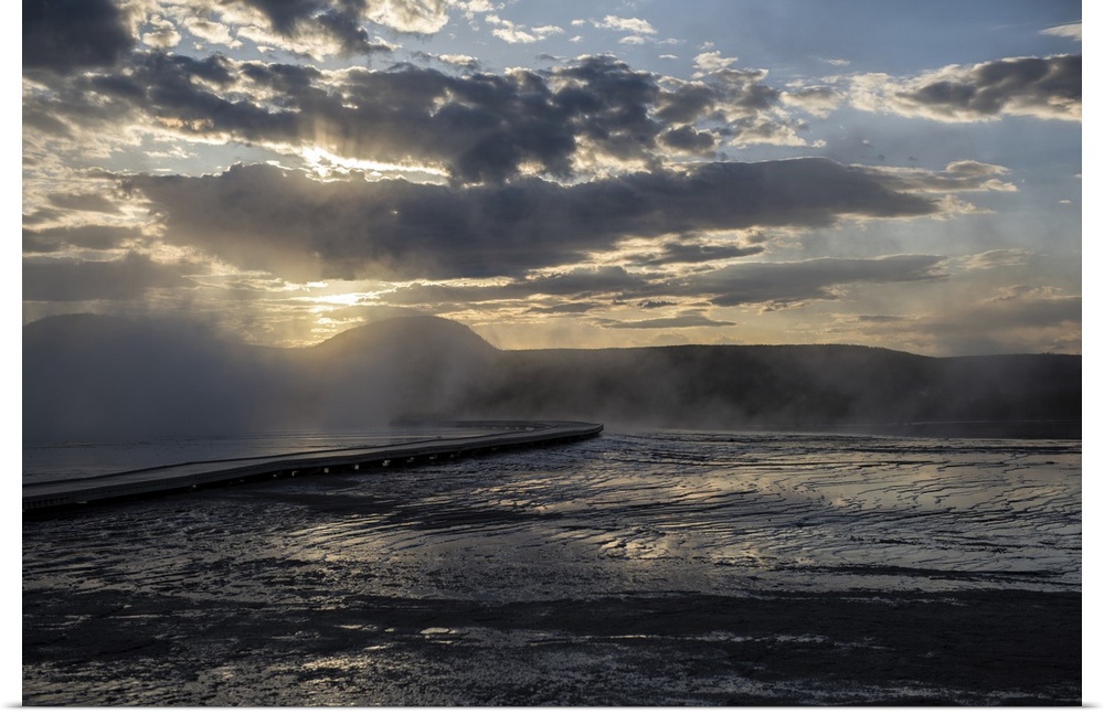 The sun rays peeking over hot springs at Yellowstone National Park.