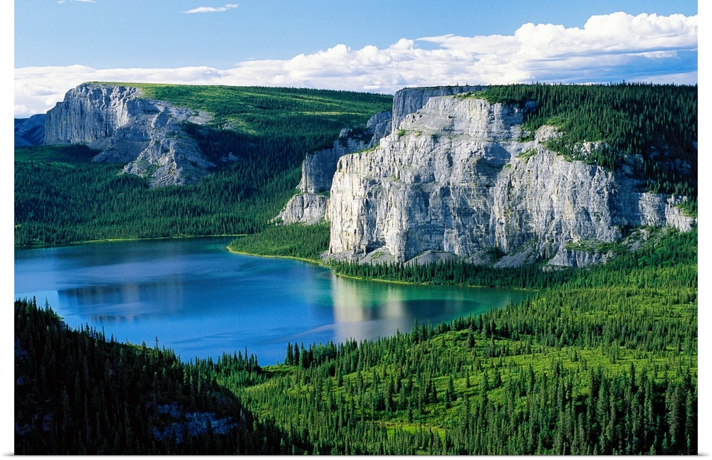 Photograph taken of immense cliffs known as Death Lake. The land is blanketed with trees and the lake sits in the center o...