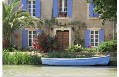 Boat moored alongside house on the bank of the Canal du Midi, France