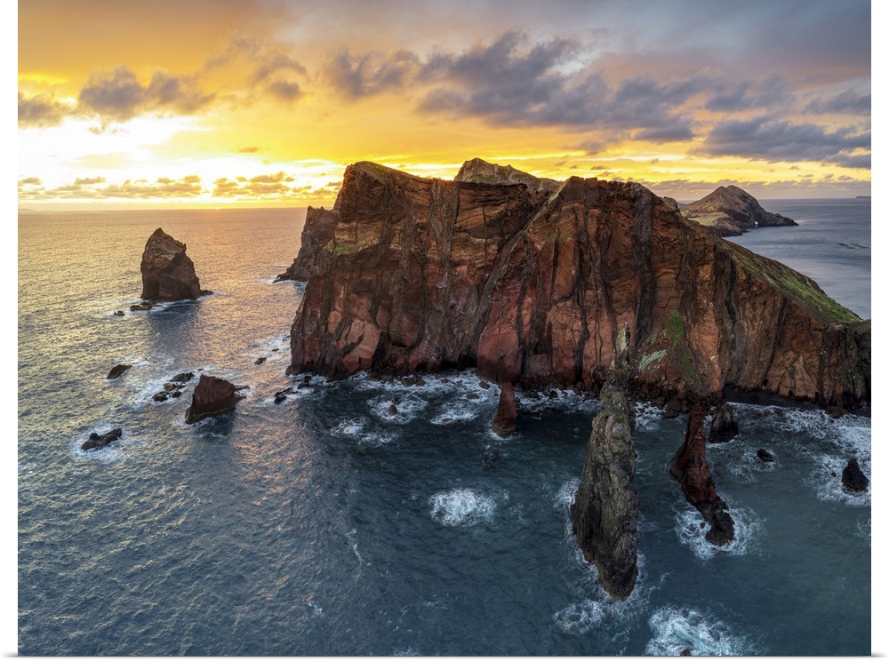 Burning sky at dawn on cliffs washed by ocean, Ponta do Rosto viewpoint, Sao Lourenco Peninsula, Madeira island, Portugal,...