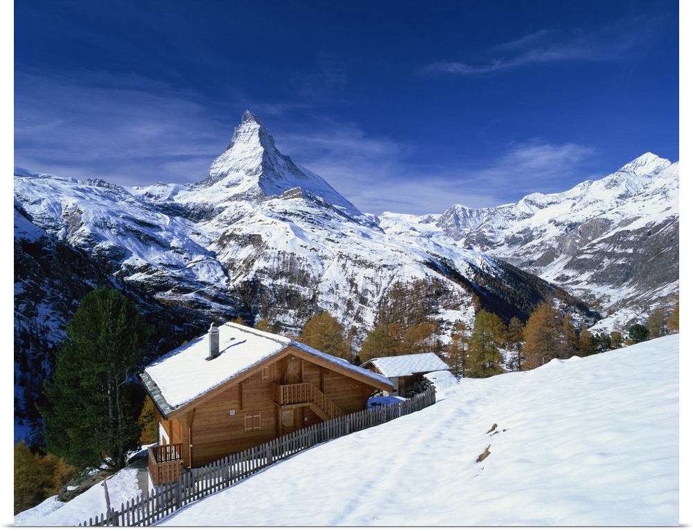 Chalets in a snowy landscape with the Matterhorn peak, Swiss Alps, Switzerland