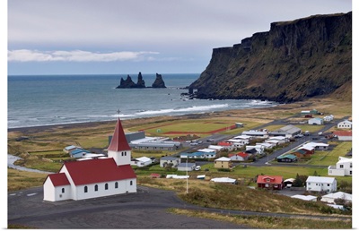 Church, village of Vik and Reynisdrangar sea stacks in the distance, Iceland