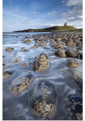 Dunstanburgh Castle From The Rocky Shores Of Embleton Bay, Northumberland, England, UK