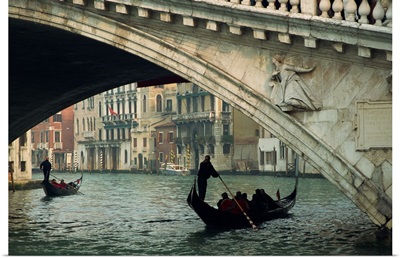 Gondola under the Rialto Bridge on the Grand Canal in Venice, Italy